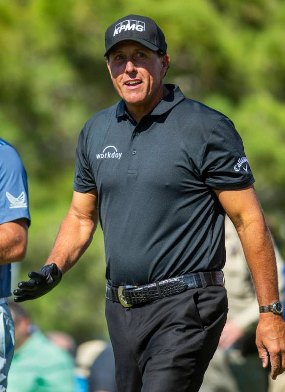 Phil Mickelson smiles at some fans as he walks up the fairway on hole 1 during the third round ...