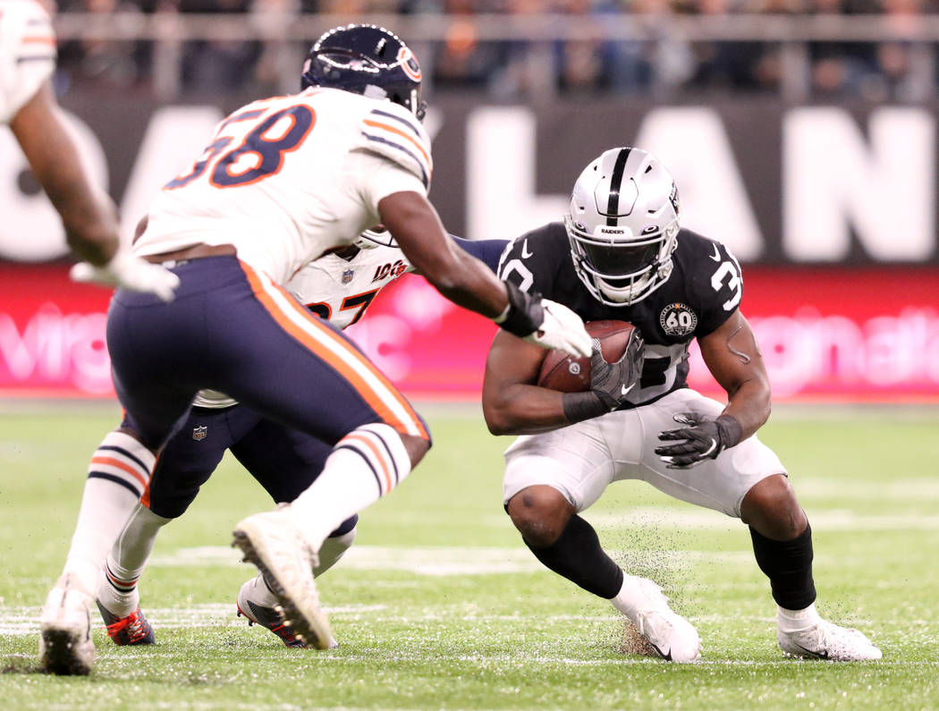 Oakland Raiders running back Jalen Richard (30) looks for room to run as Chicago Bears inside l ...