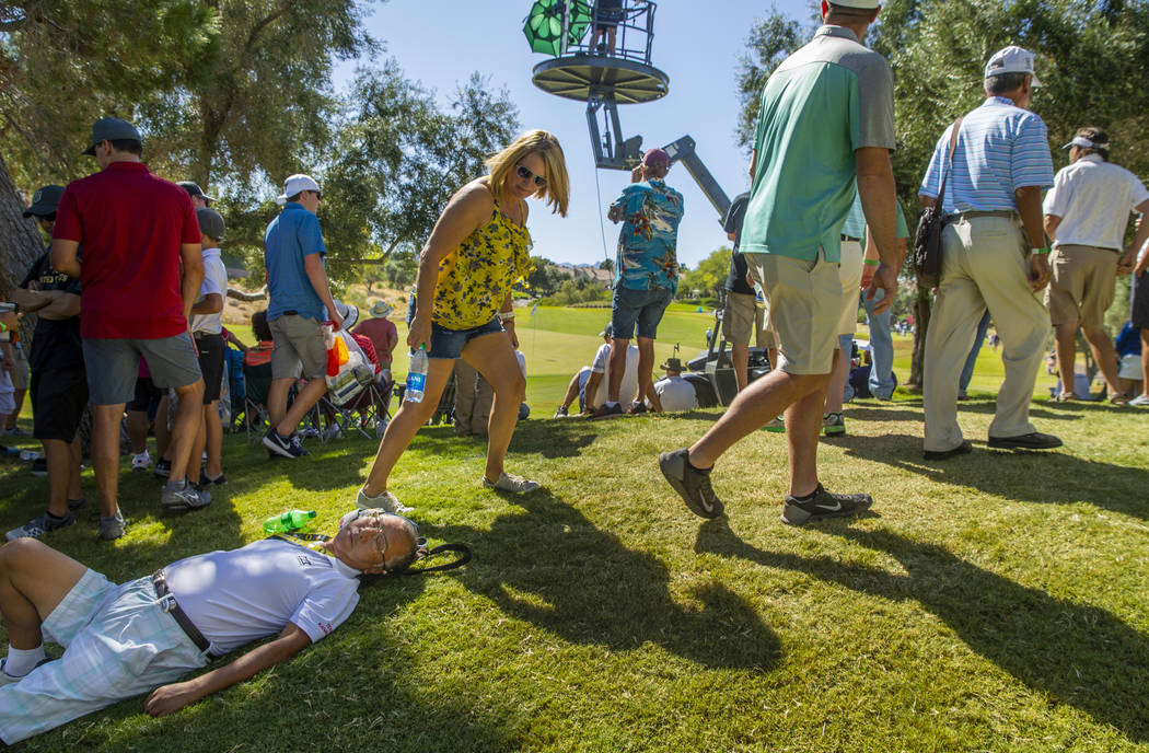 A fan is passed out near the green at hole 8 during the final round of Shriners Hospitals for C ...