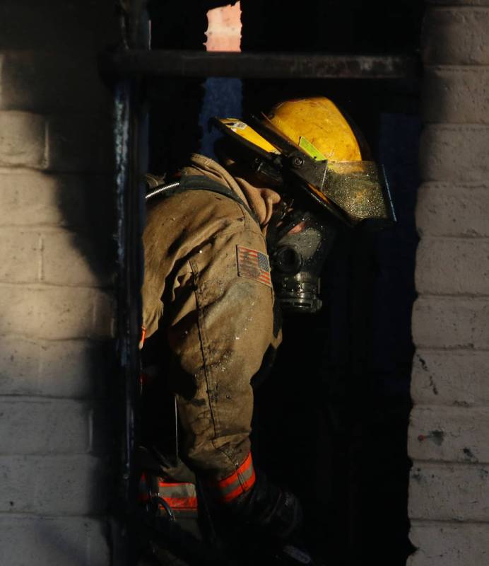 A Clark County firefighter battles a fire in a commercial area at 824 E. Sahara Ave. on Monday, ...