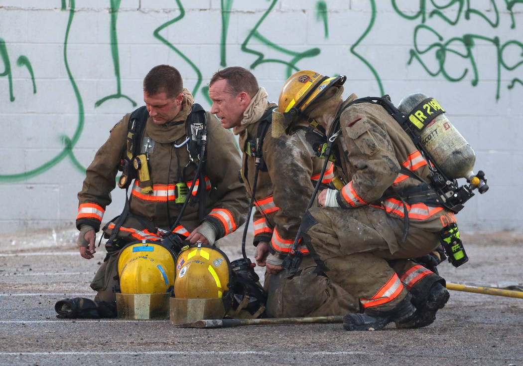 The Clark County firefighters take a break after battling a fire in a commercial area at 824 E. ...