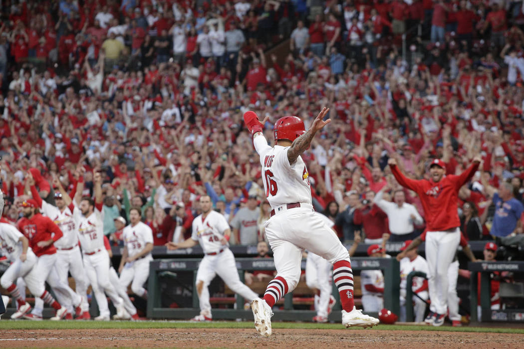 St. Louis Cardinals' Kolten Wong (16) scores the winning run on a sacrifice fly hit by Yadier M ...