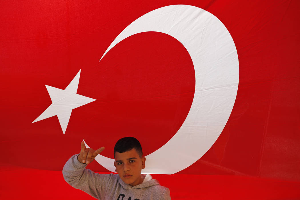 A youth flashes a hand gesture representing the Turkish far-right gray wolves organisation as h ...