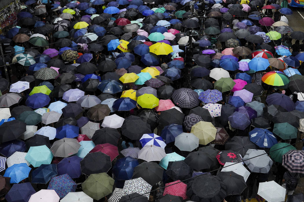 FILE - In this Oct. 6, 2019, file photo, protesters march in the rain on a street in Hong Kong. ...