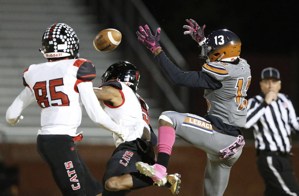 Legacy's Aaron Holloway (13) cannot catch a pass as Las Vegas' Jaelin Gray (85) and Devyn Perki ...