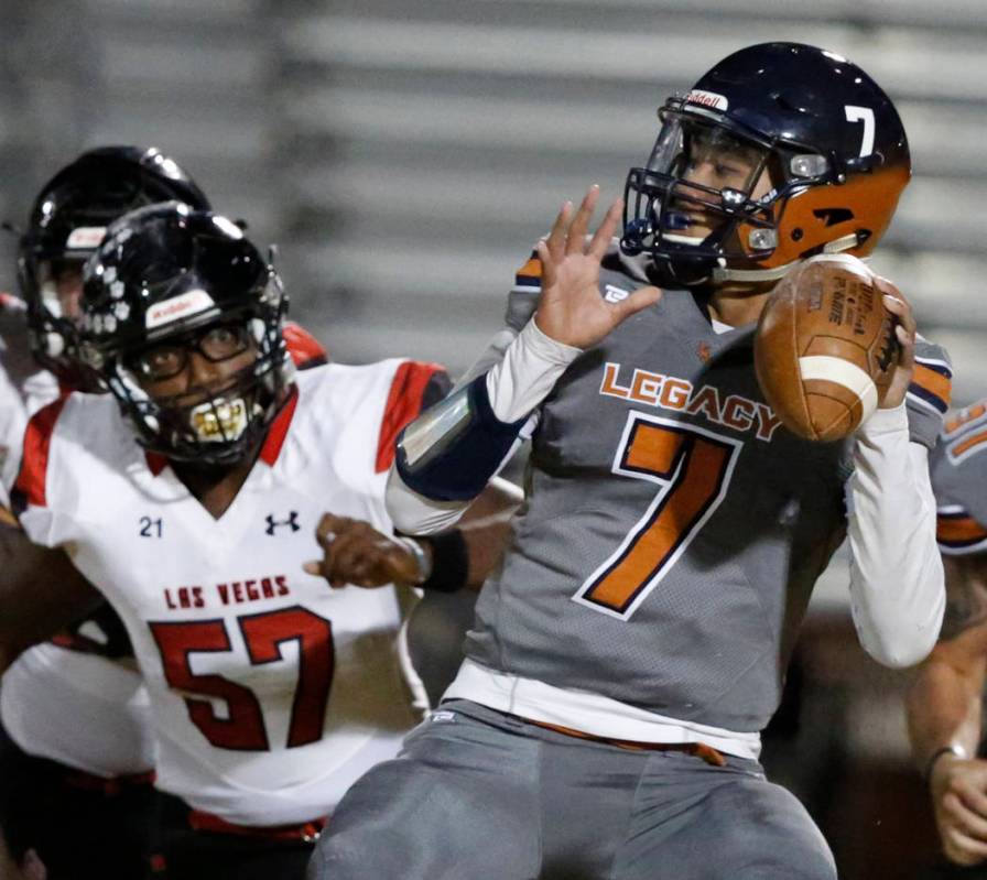 Legacy's quarterback Evan Olaes (7) looks to throw the ball as Las Vegas' Markell Jackson (57) ...