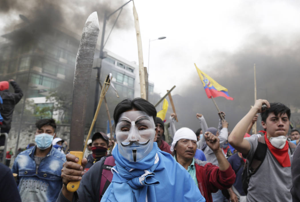 Anti-government protesters clash with police near the National Assembly in Quito, Ecuador, Tues ...