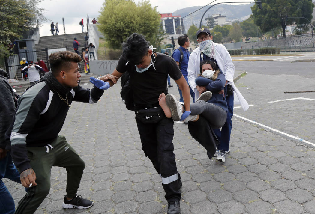 An injured anti-government protester is carried away by paramedics during clashes with police n ...