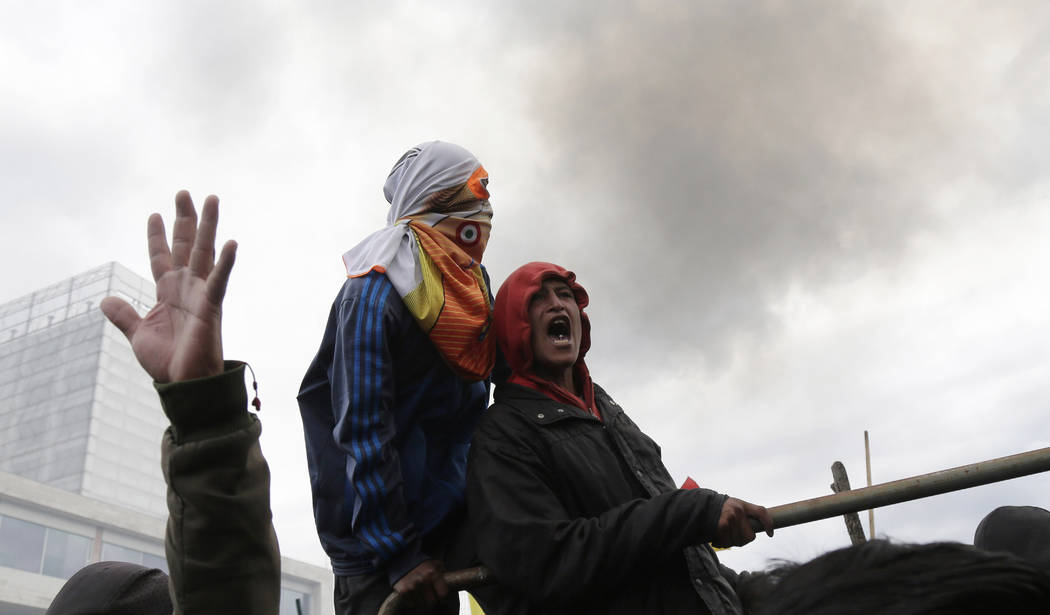 Anti-government protesters clash with police near the National Assembly in Quito, Ecuador, Tues ...