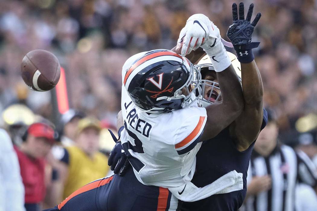 Virginia wide receiver Joe Reed, left, or Notre Dame cornerback Troy Pride Jr. both come up sho ...