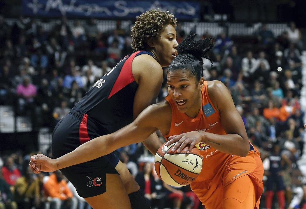 Connecticut Sun's Alyssa Thomas, front, drives past Washington Mystics' Tianna Hawkins during t ...