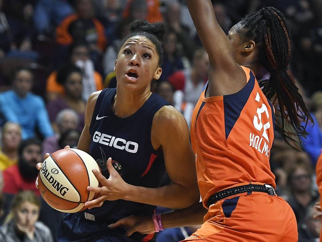 Washington Mystics' Aerial Powers, left, drives to the basket as Connecticut Sun's Bria Holmes ...