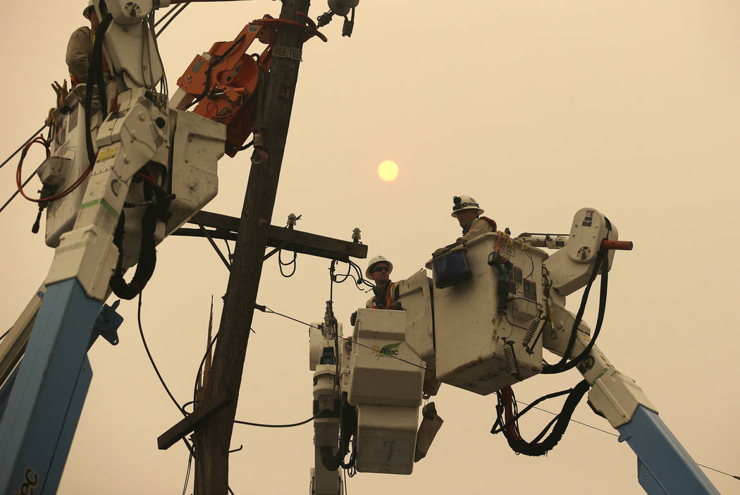 Pacific Gas & Electric crews work to restore power lines in Paradise, Calif., Nov. 9, 2018. Two ...