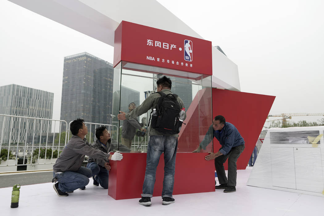 Workers dismantle signage for an NBA fan event scheduled to be held on Wednesday night at the S ...