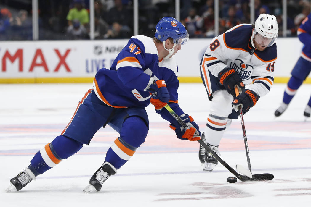 Edmonton Oilers left wing James Neal (18) defends against New York Islanders center Leo Komarov ...