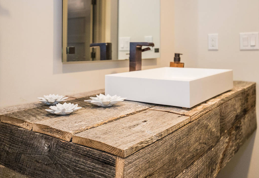 The guest bath features a wood vanity and stone sinks. (Tonya Harvey/Real Estate Millions)