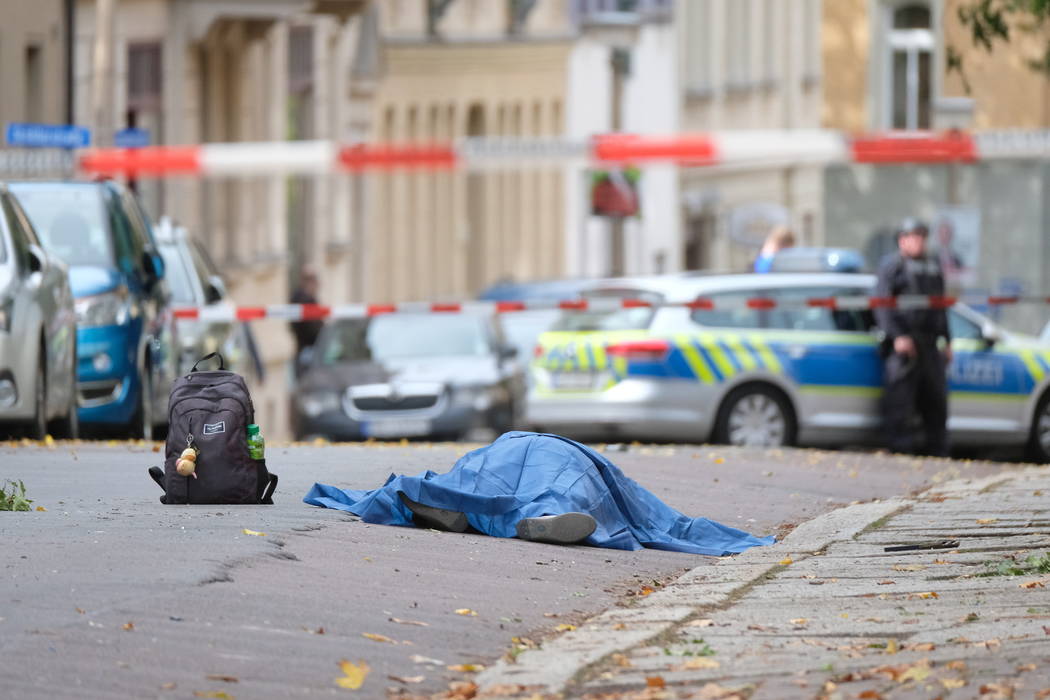 A body lies on a road in Halle, Germany, Wednesday, Oct. 9, 2019 after a shooting incident. A g ...