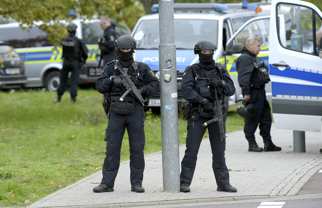 Police officers block a road in Halle, Germany, Wednesday, Oct. 9, 2019. One or more gunmen fir ...