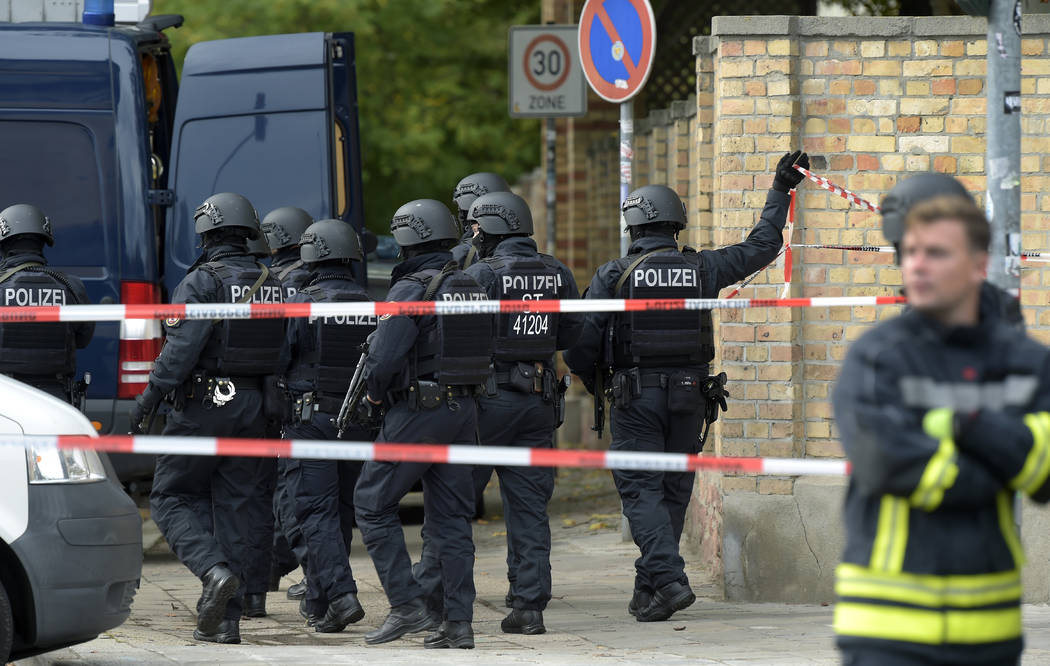 Police officers walk in front of a Jewish cemetery in Halle, Germany, Wednesday, Oct. 9, 2019. ...