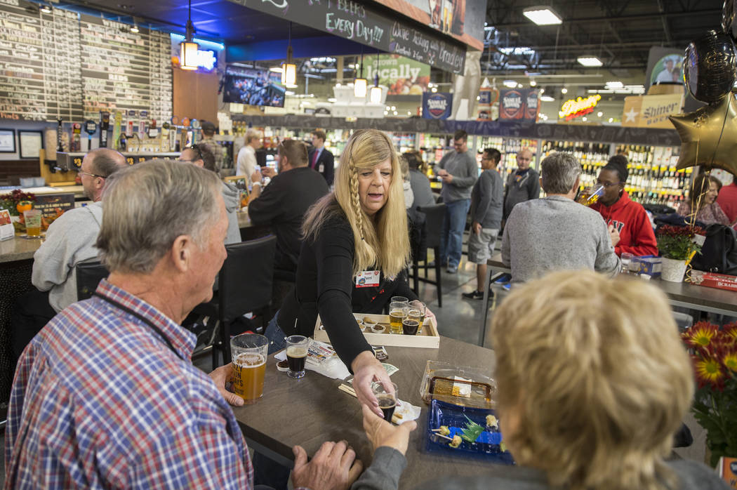 Bartender Terri Wirthlin, middle, hands out beer samples at Social Hour Beer and Wine Bar on Th ...