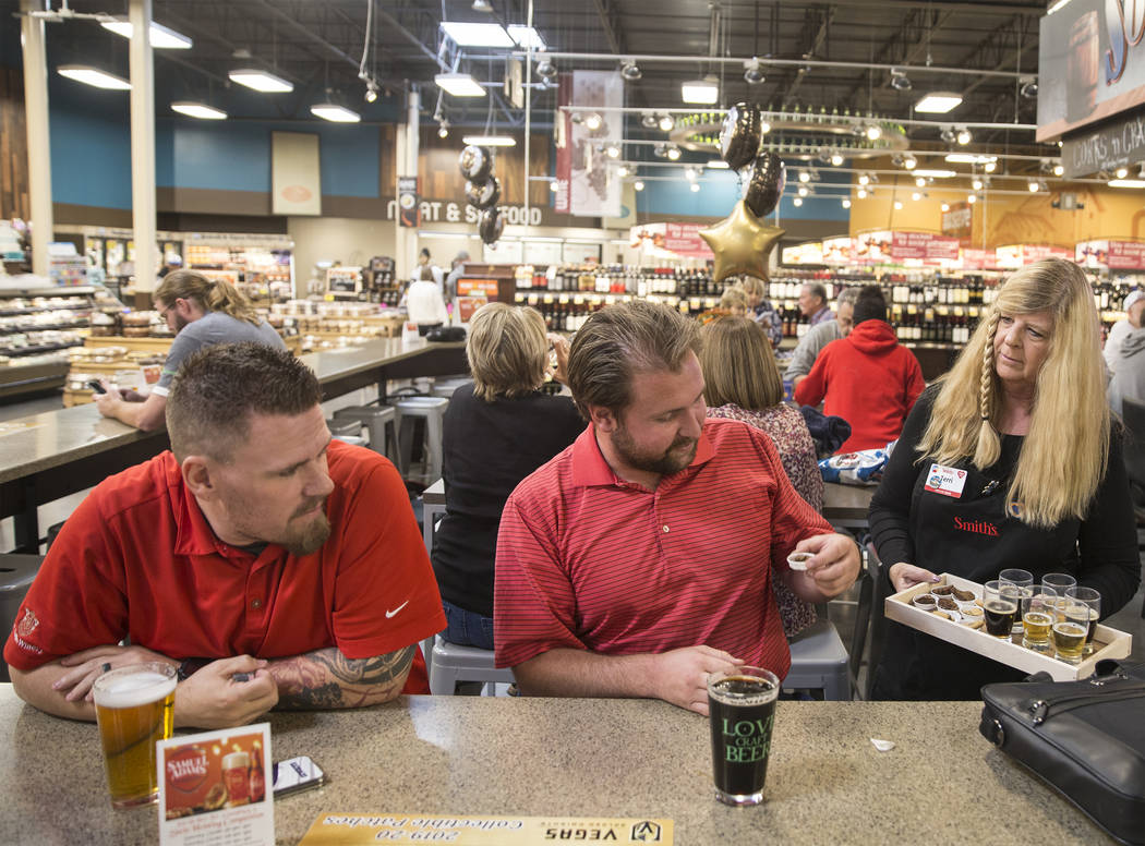 Bartender Terri Wirthlin, right, hands out beer samples to Patrick Shearer, middle, and Donnie ...