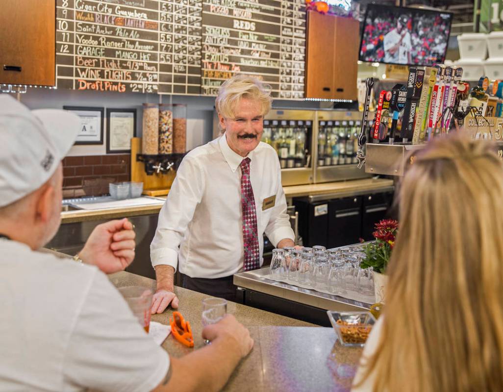 Wine steward Bradley Pugh, middle, talks with patrons at Social Hour Beer and Wine Bar on Thurs ...