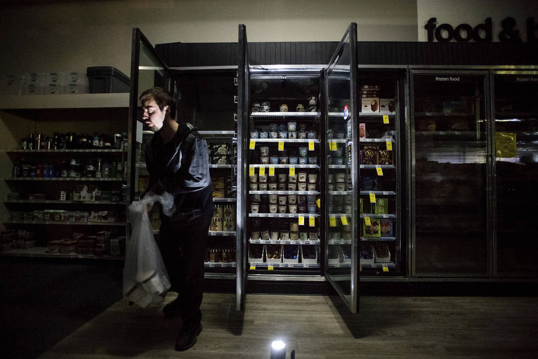 CVS Pharmacy shift supervisor James Quinn throws out ice cream from darkened freezers as downto ...