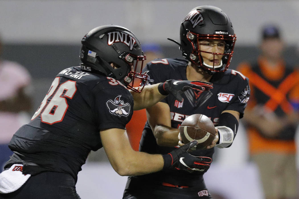 UNLV quarterback Kenyon Oblad (7) hands the ball off to running back Chad Magyar during the fir ...