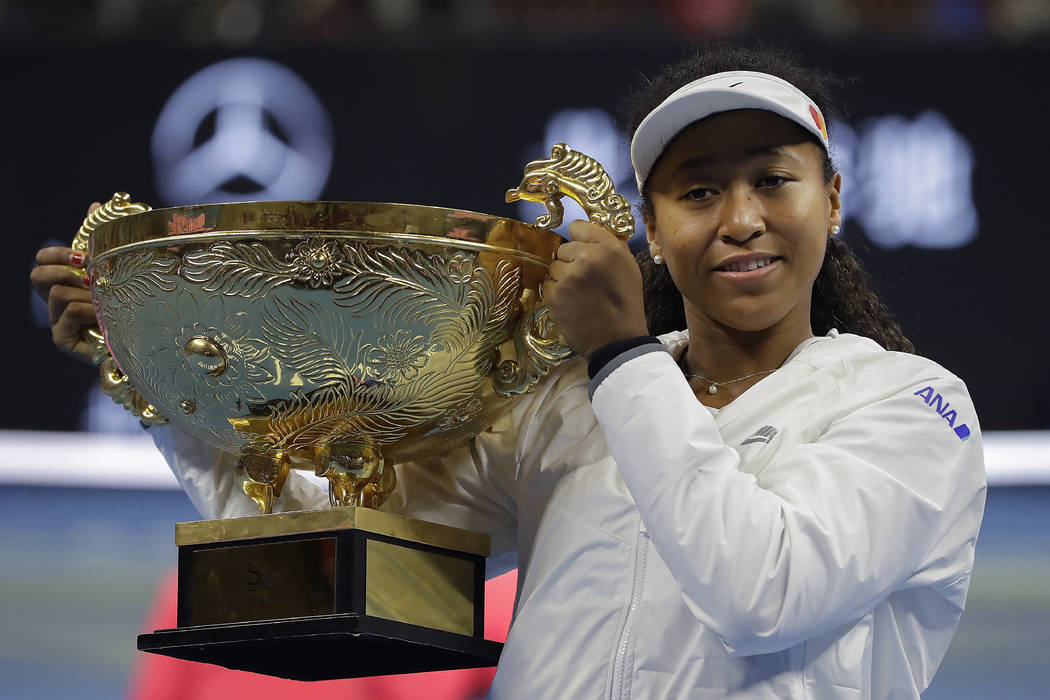 Naomi Osaka of Japan poses with her winner's trophy after defeating Ashleigh Barty of Australia ...