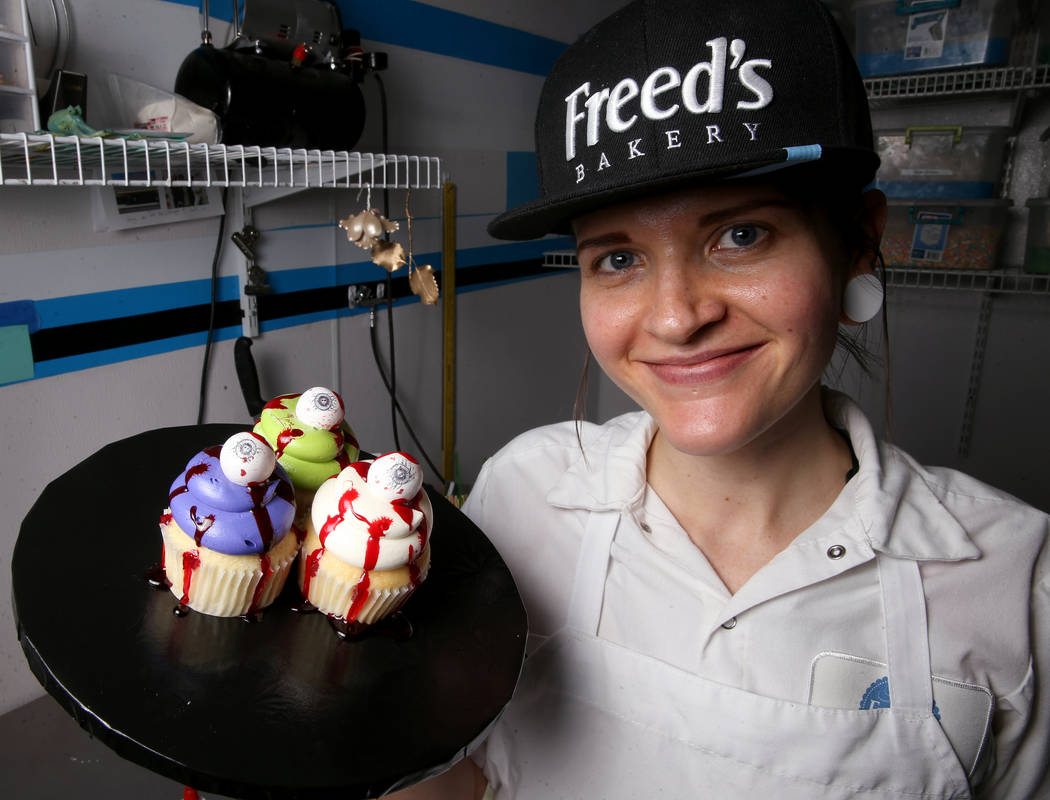 Brittnee Klinger, a cake decorator at Freed's Bakery in Las Vegas shows cupcakes with fake bloo ...