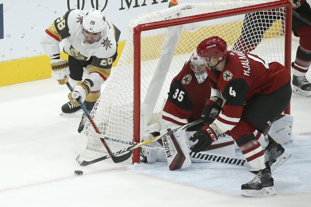 Arizona Coyotes goaltender Darcy Kuemper (35) gets some help from defenseman Niklas Hjalmarsson ...