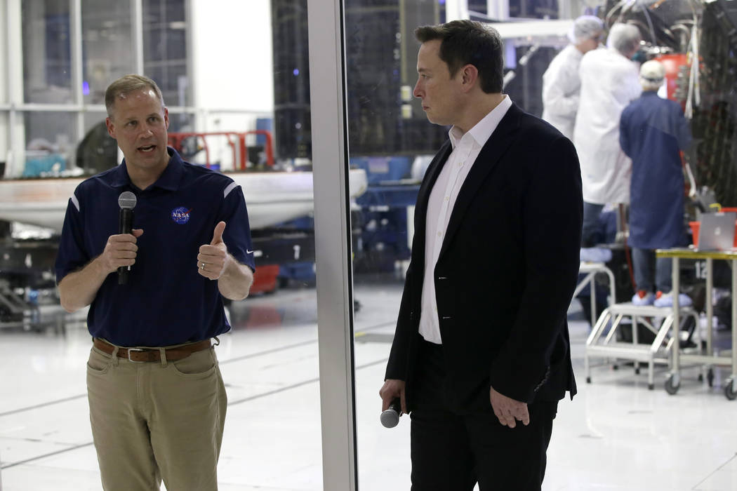 NASA Administrator Jim Bridenstine, left, talks with SpaceX chief engineer Elon Musk, right, in ...