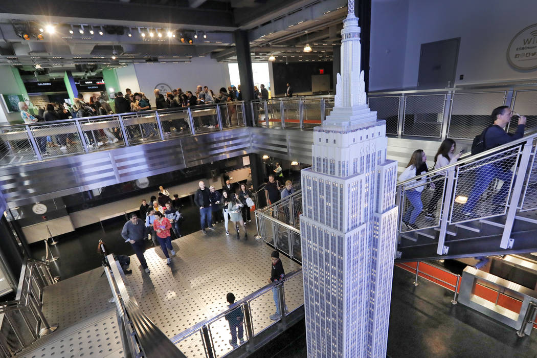 Visitors to the Empire State Building pass a scale model of the building as they begin their vi ...