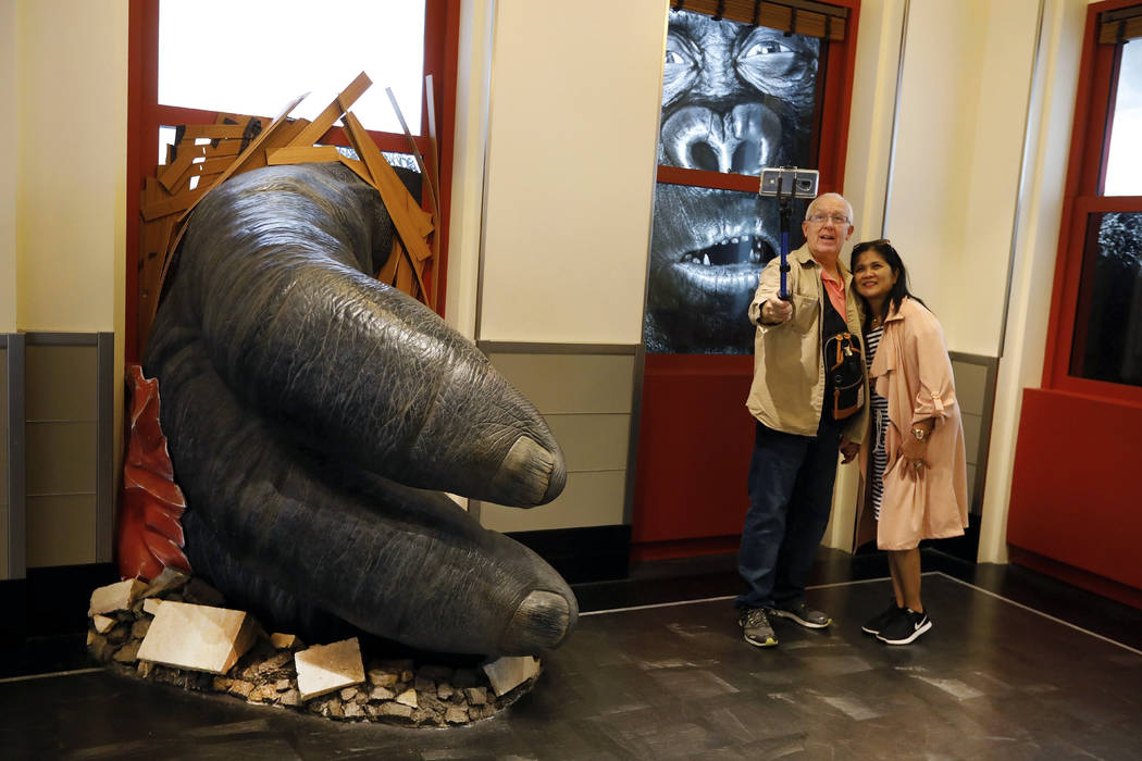 Visitors to the Empire State Building take a photo featuring an interactive King Kong exhibit, ...