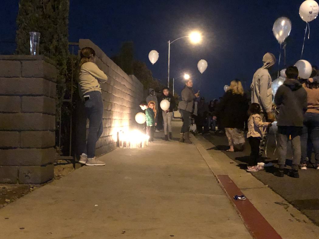 Nearly a hundred mourners gathered on Friday, Oct. 11, 2019, outside the Viridian Apartments, 4 ...