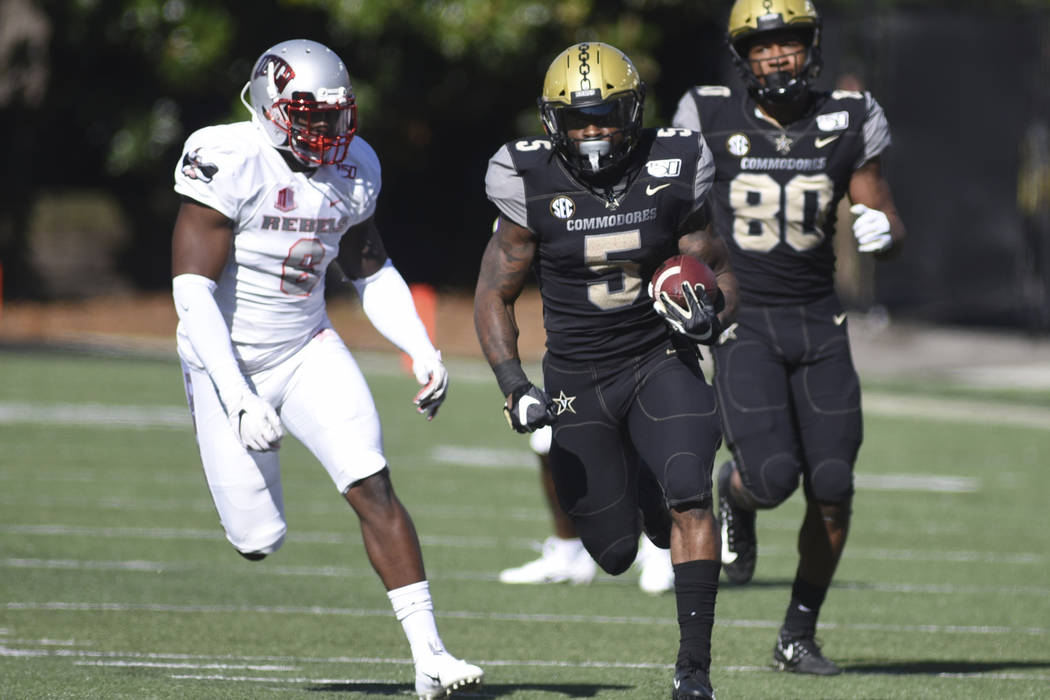 Vanderbilt running back Ke'Shawn Vaughn runs with the ball past UNLV linebacker Rayshad Jackson ...