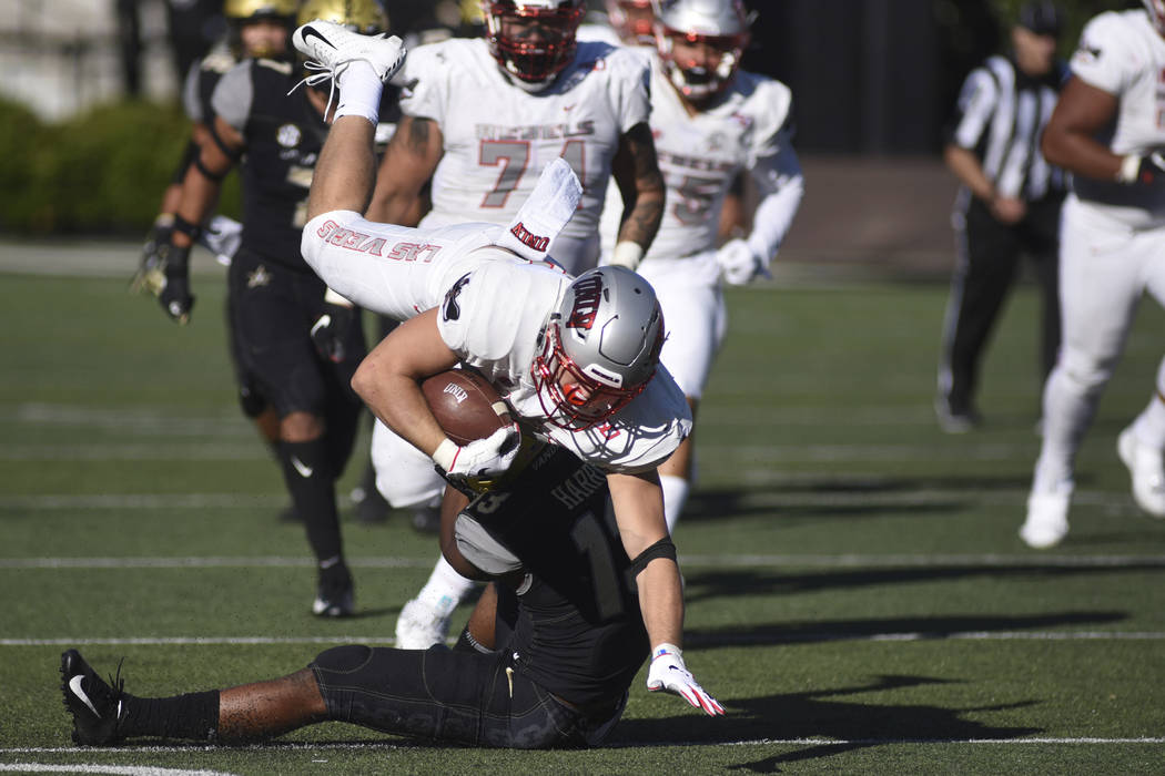 UNLV running back Chad Maygar, top, is tackled by Vanderbilt defender Brendon Harris, bottom, i ...