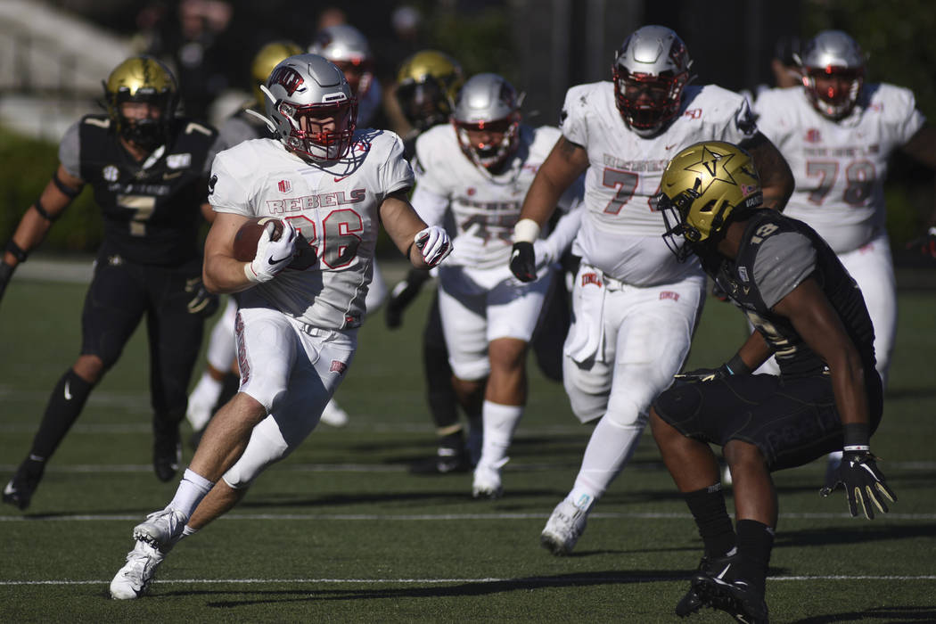 UNLV running back Chad Maygar (38) runs next to Vanderbilt defender Brendon Harris (13) in the ...