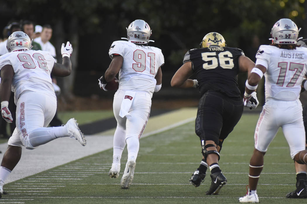 UNLV defensive end Nate Neal (91) returns a fumble past Vanderbilt lineman Saige Young (56) in ...