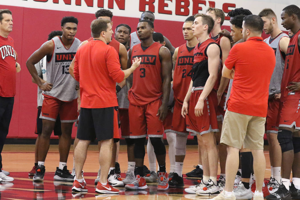 UNLV Rebels head coach T.J. Otzelberger, center, talks to his players after team's first basket ...