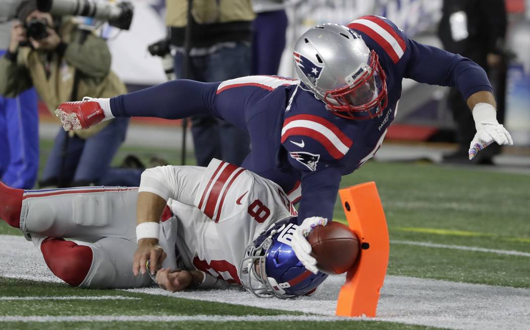 New England Patriots linebacker Kyle Van Noy dives over New York Giants quarterback Daniel Jone ...