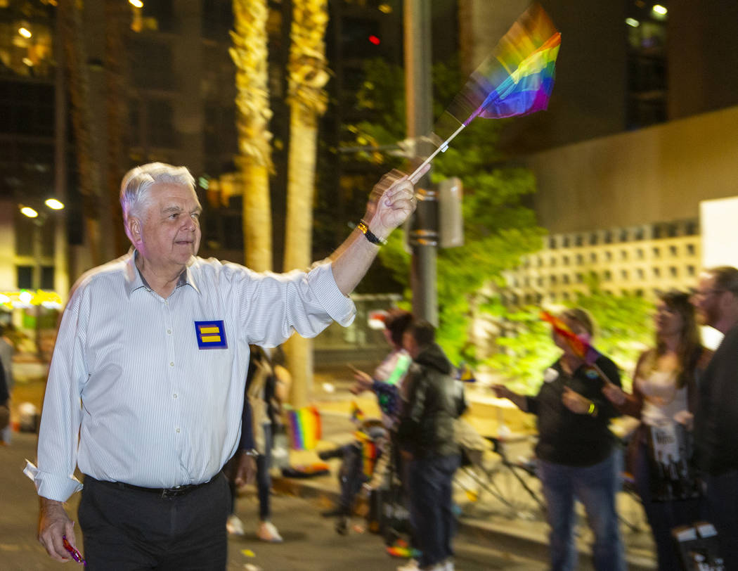 Gov. Steve Sisolak waves a flag while marching in the Pride parade on Friday, Oct. 11, 2019 in ...