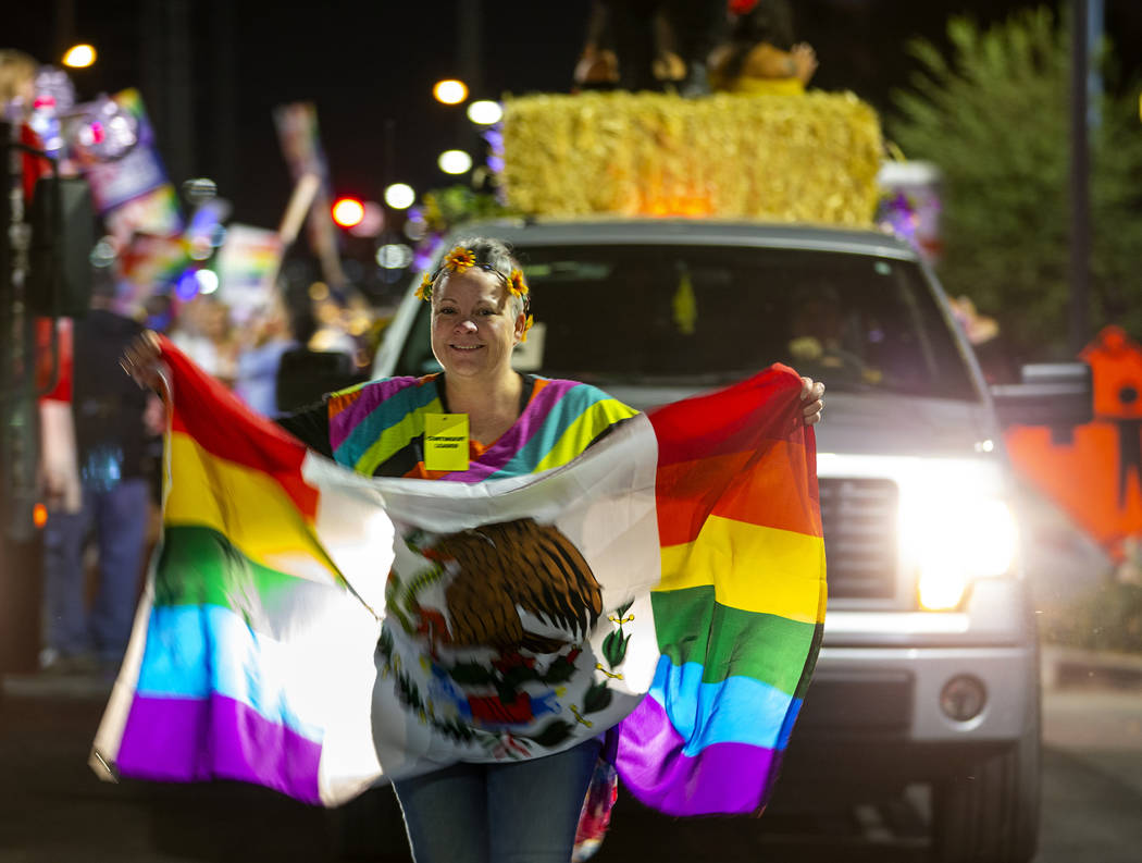 A participant carries a flag while leading her float during the annual Las Vegas Pride Night Pa ...