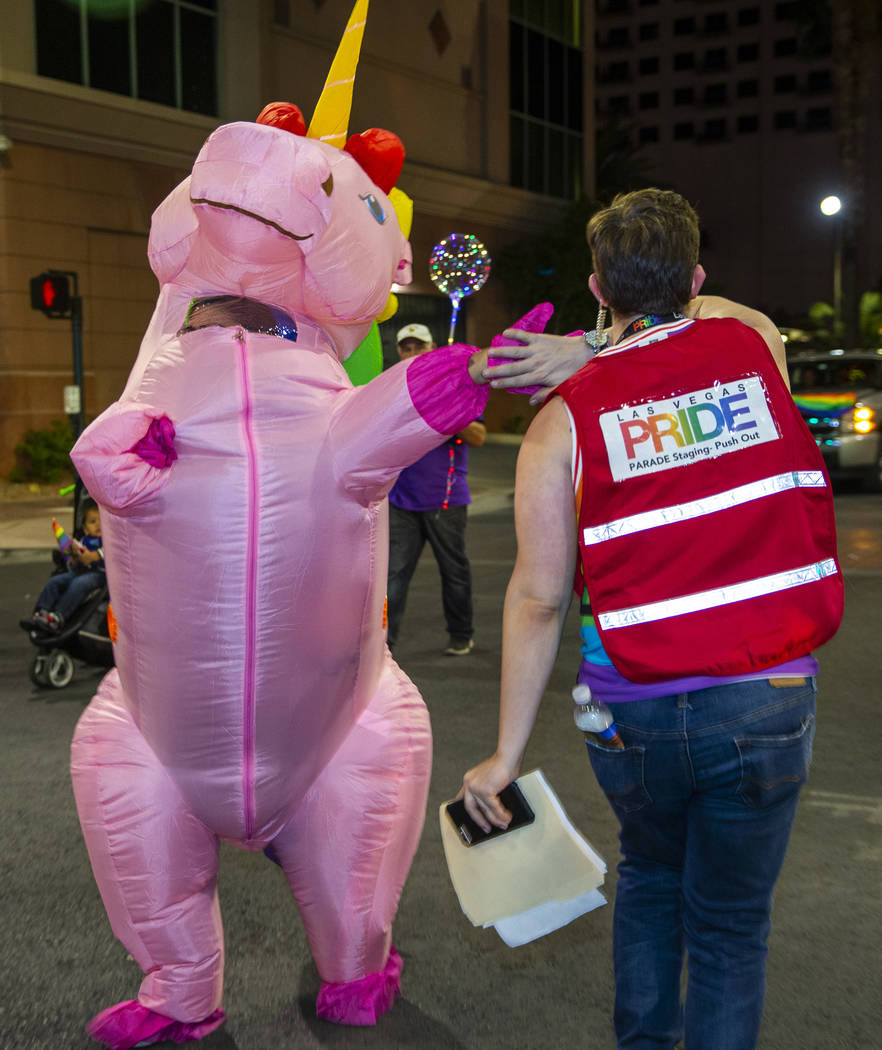 A marching pink unicorn gives a "high five" to an event coordinator during the annual Las Vegas ...