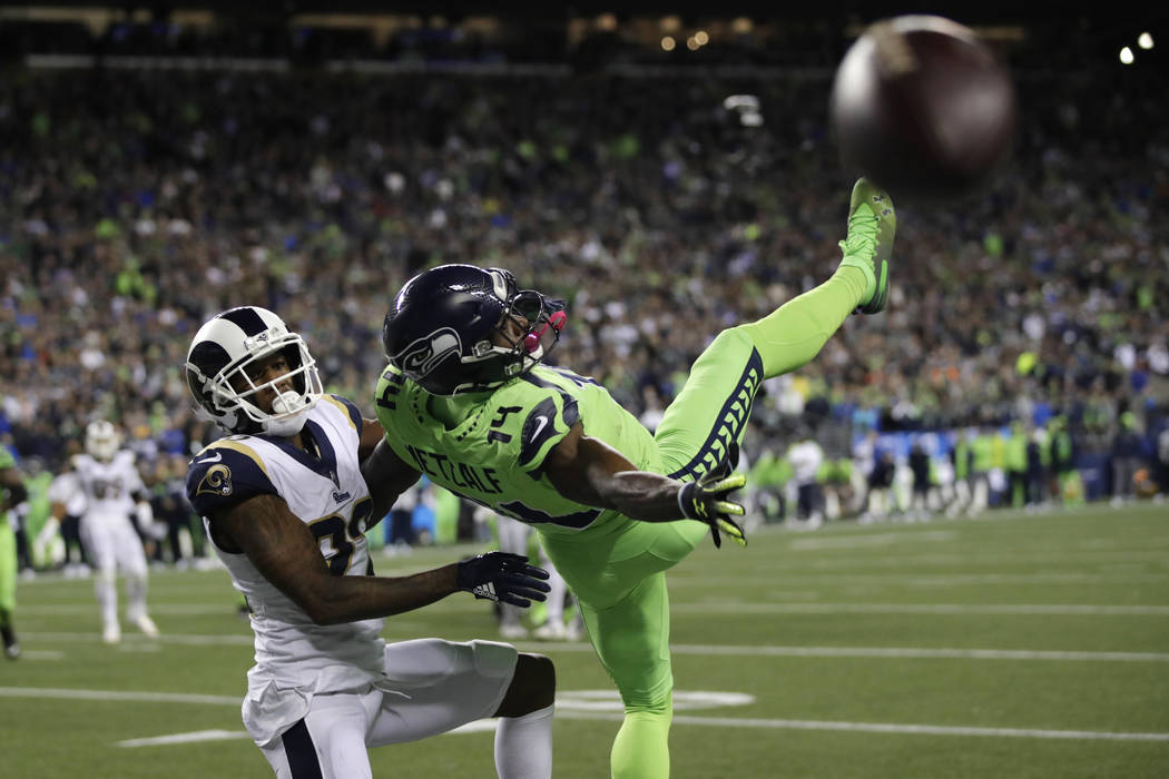 Seattle Seahawks wide receiver DK Metcalf, right, goes down next to Los Angeles Rams cornerback ...