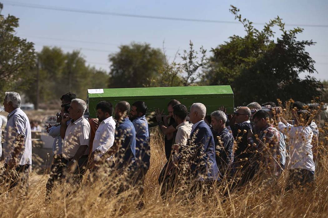 Mourners carry the coffin of Halil Yagmur, 64 killed Friday during mortar shelling from Syria, ...