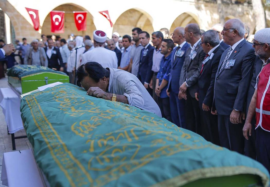 A mourner cries on the coffin of Halil Yagmur, 64, killed Friday during mortar shelling from Sy ...