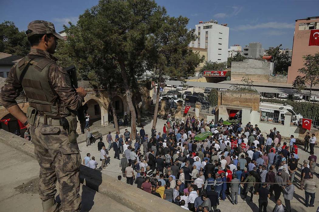 A Turkish soldier watches as mourners carry the coffins of Halil Yagmur, 64 and Muslum Guzel, k ...