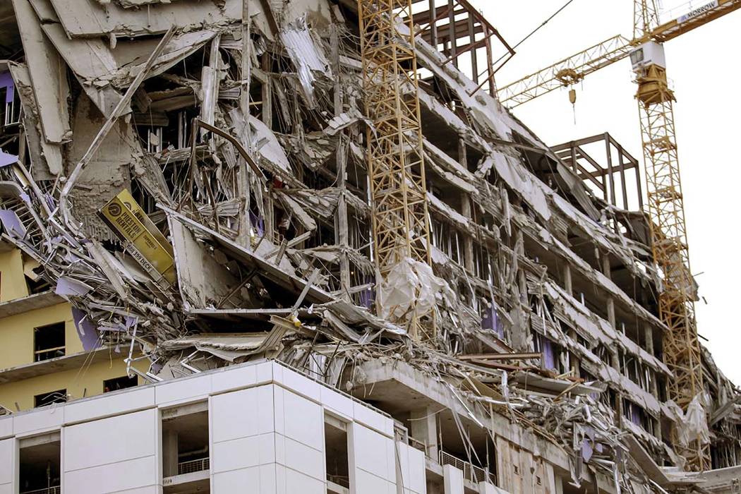 Debris hangs on the side of the building after a large portion of a hotel under construction su ...