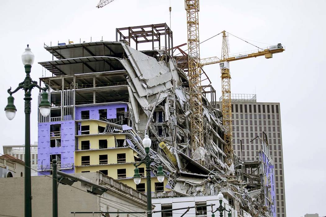 Debris hangs on the side of the building after a large portion of a hotel under construction su ...